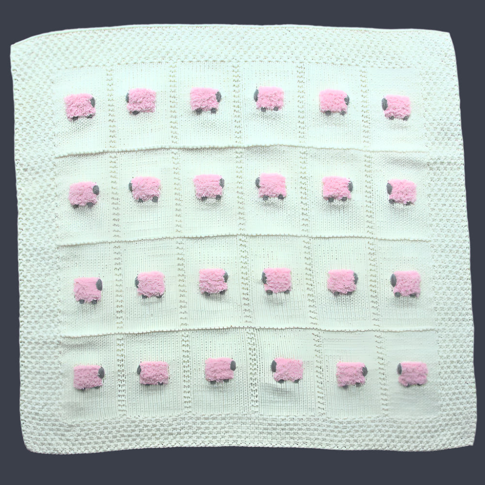 Creamy white hand-knitted baby blanket with pink fluffy sheep