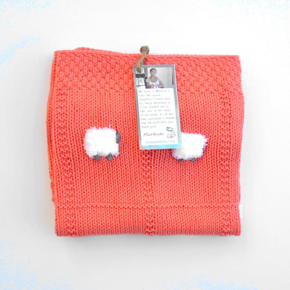 Lightweight coral baby blanket with fluffy white sheep.