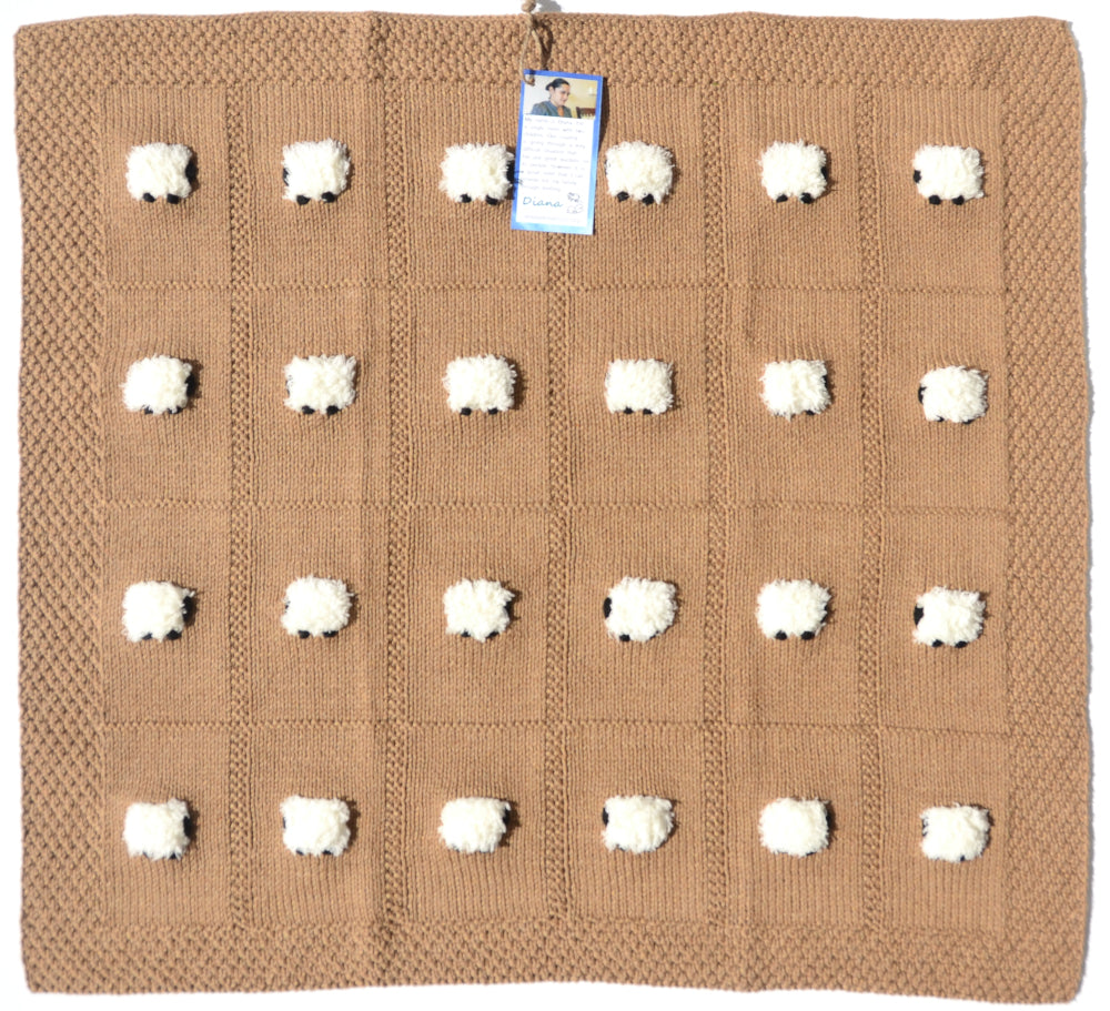Square baby blanket laid out with 24 fluffy sheep. The color is khaki, or acorn.
