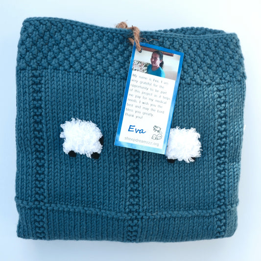 Cadet blue chunky baby blanket, folded, with two fluffy white sheep.