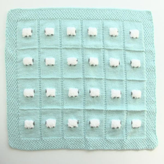Minty green wool-based baby blanket with 24 fluffy sheep - all knitted by hand.