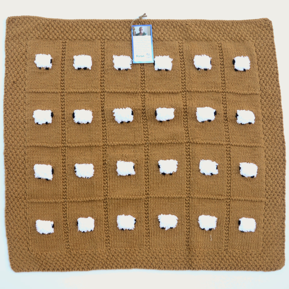 Wool blend handmade baby blanket. Color is like a ginger snap with 24 fluffy white sheep.