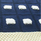 Close-up of navy blue baby blanket with a cream border