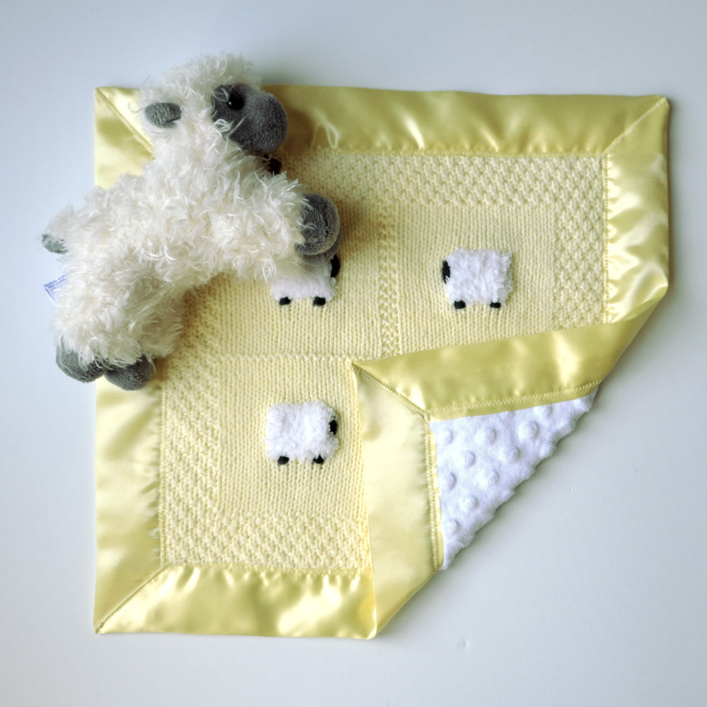 Pastel yellow baby lovey with four sheep and a doll
