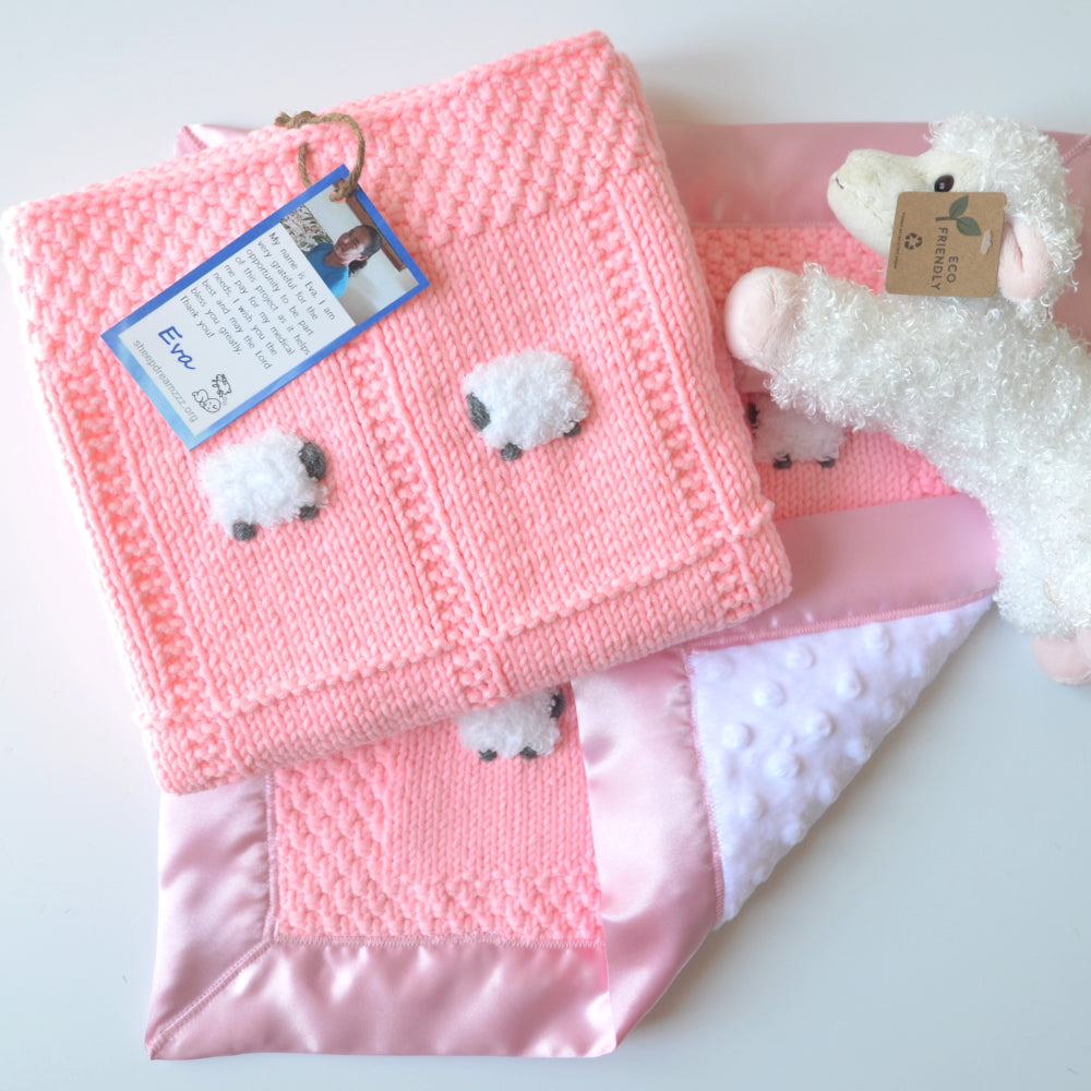 Bright peachy pink baby gift set with blanket, lovey, and sheep doll