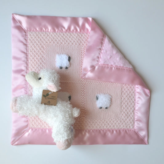 Pastel pink hand-knitted lovey with a satin border and a fluffy sheep doll.