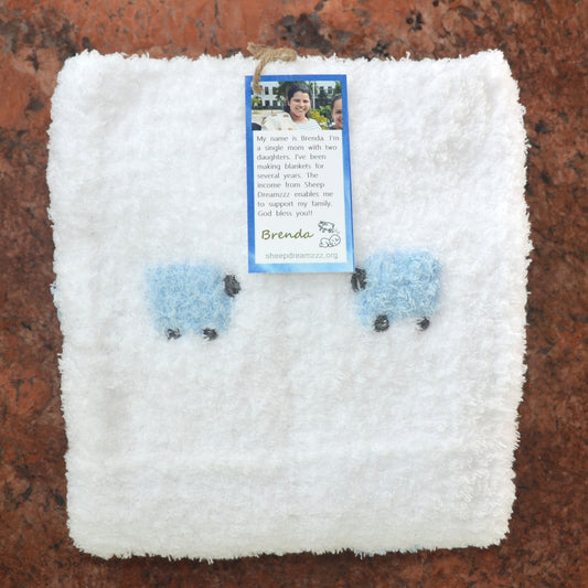 Folded white sherpa/fleece baby blanket with two fluffy blue sheep showing.