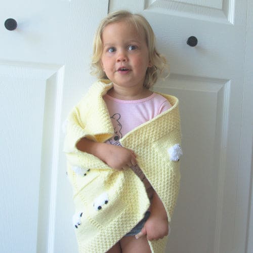 Toddler girl wrapped in her pastel yellow Angel Soft baby blanket