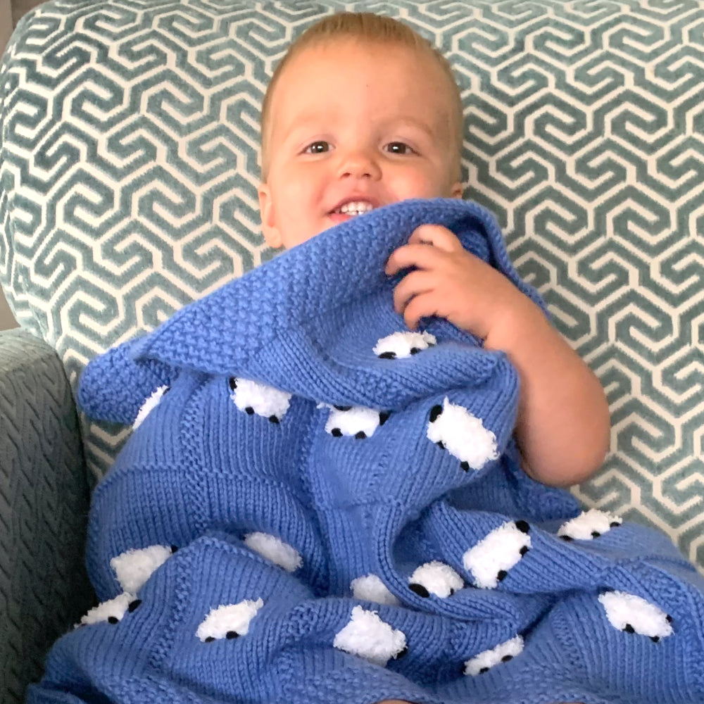 Bright cornflower blue chunky baby blanket with a baby boy