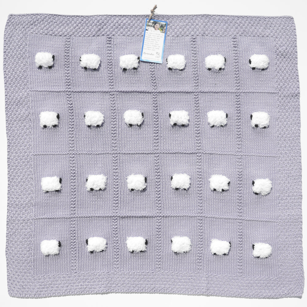 Full, flat view of lavender lightweight 60% pima cotton jand-knitted baby blanket with 24 fluffy white sheep.