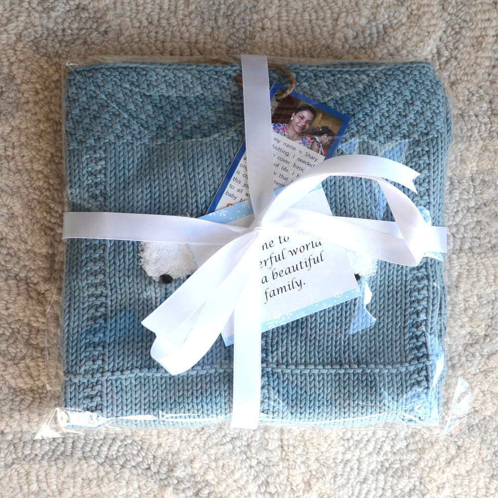 Moonstone blue baby blanket in standard Sheep Dreamzzz blanket packaging - clear cellophane pouch with a satin ribbon wrapped around.
