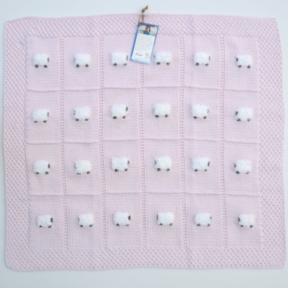 Pale pink baby blanket hand-knitted with 24 sheep.