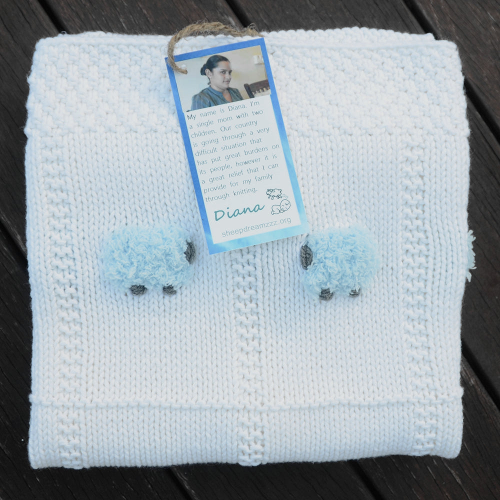 White pima cotton blanket with blue sheep. Hand-knitted.