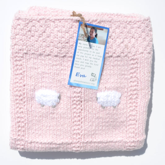 Light pink organic baby blanket, folded, with two of its 24 white sheep showing.