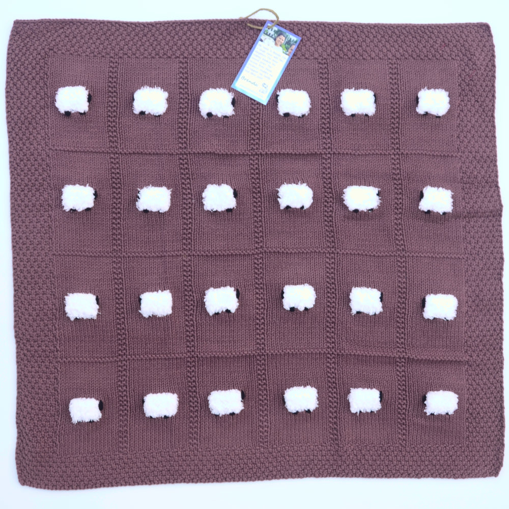 Hand-knitted baby blanket in red sangria color with 24 fluffy sheep.