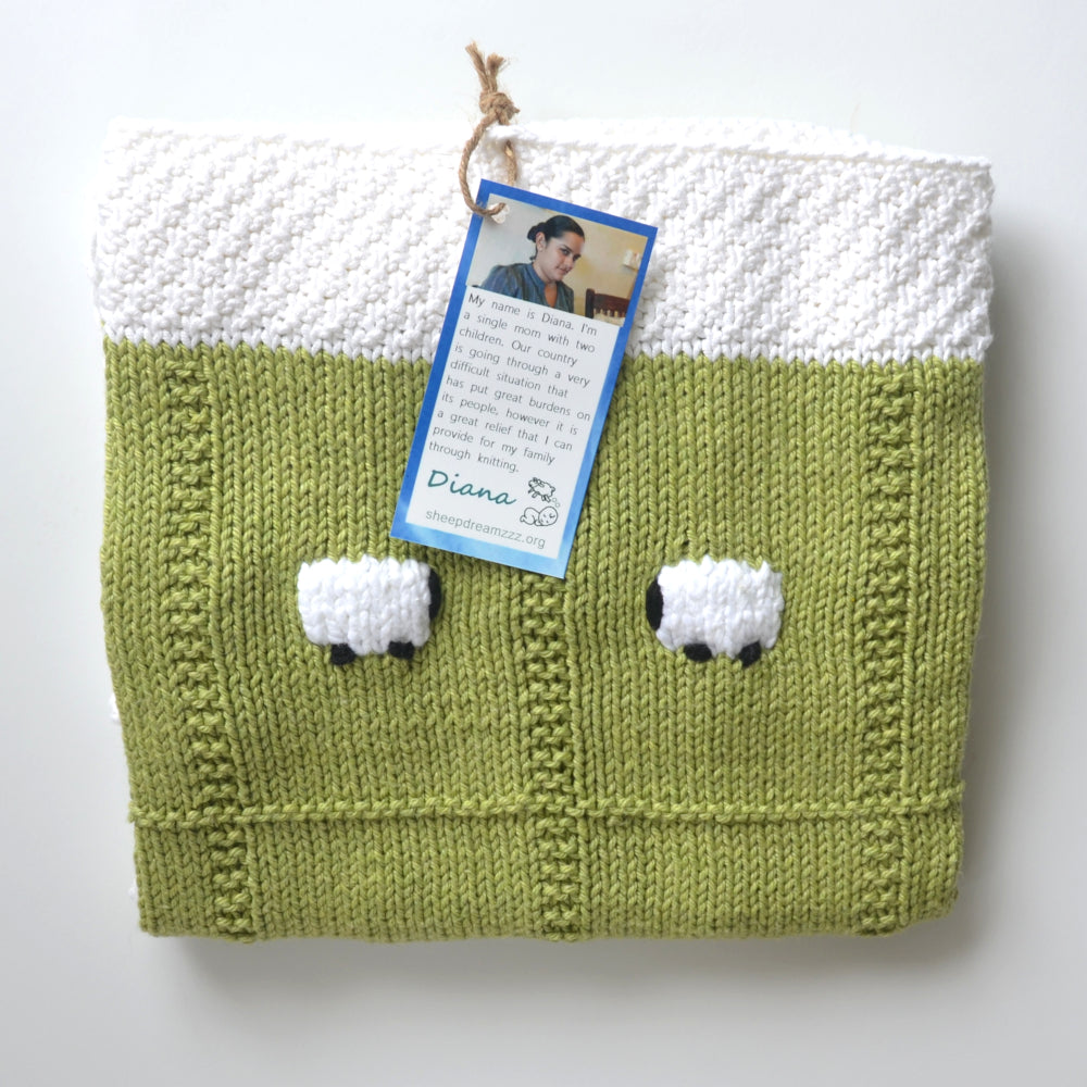 Tea green lightweight baby blanket with a white border.