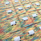 Close-up of our Toybox baby blanket in the colors of the basic lego bricks and pieces