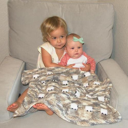 Two little sisters kept warm under a Cookies and Cream wool-based blanket. Very soft and silky.