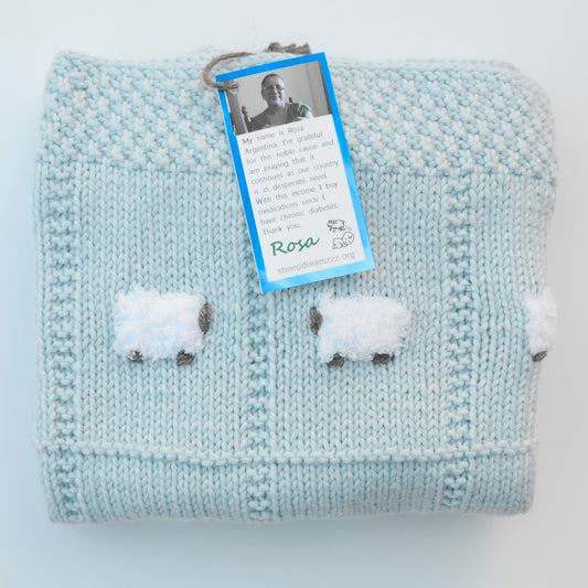 Wool blend hand-knitted baby blanket in baby blue.